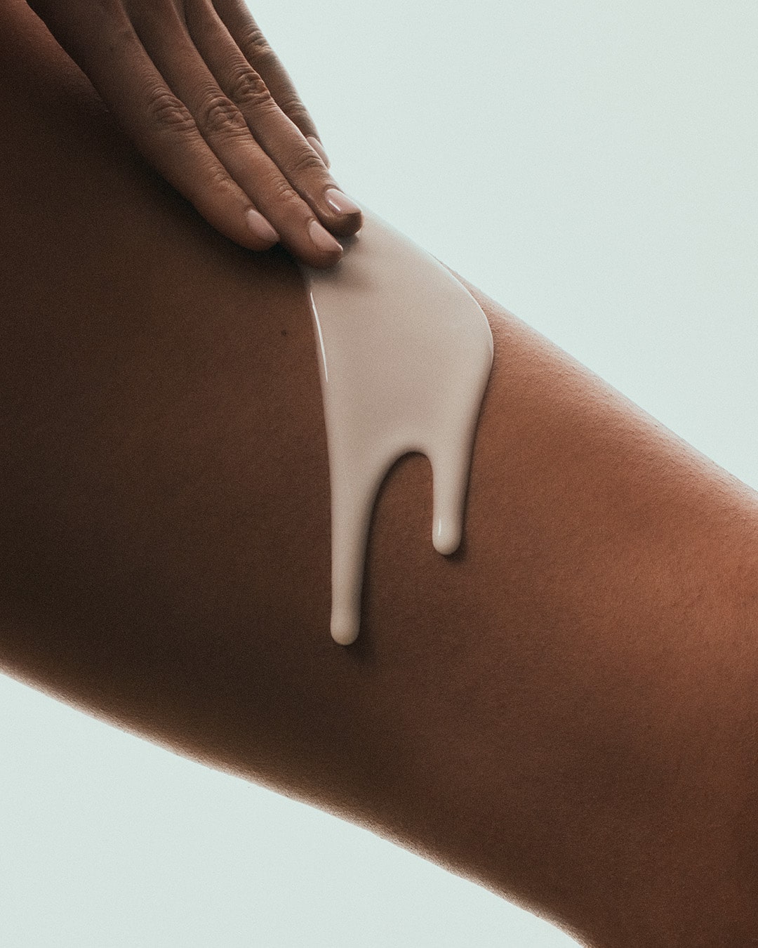 Applying Luisante brightening body serum on smooth skin for radiant and even tone